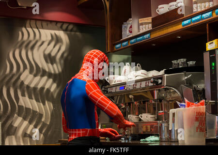 Person verkleidet als Figur Spiderman machen Kaffee im Café Derbyshire England Staunen Stockfoto