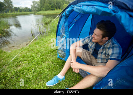 glücklich Jüngling sitzt im Zelt beim camping Stockfoto