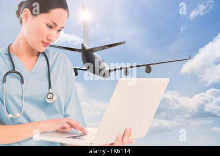 Das zusammengesetzte Bild von konzentriertem Chirurg mit einem Laptop im Krankenhaus Stockfoto