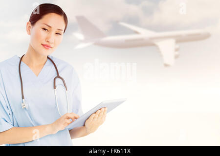 Zusammengesetztes Bild des Chirurgen mit digital-Tablette mit Gruppe Tisch im Krankenhaus Stockfoto