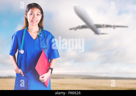 Zusammengesetztes Bild asiatische Krankenschwester mit Stethoskop in die Kamera schaut Stockfoto