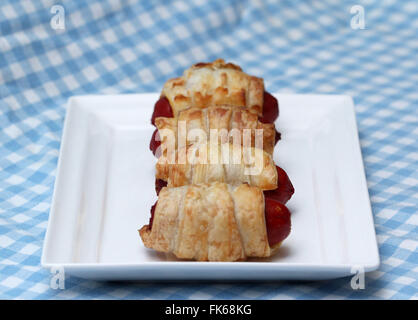 Schweine in Decke, Brötchen Wurst überdachte Blätterteig auf weißen Teller Stockfoto