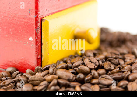 Kaffee Bohnen vor einer Kaffeemühle mit weißem Hintergrund Stockfoto