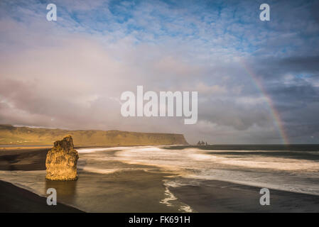 Reynisdrangar Basalt Felsnadeln und Regenbogen gesehen von der Halbinsel Dyrhólaey bei Sonnenuntergang, in der Nähe von Vik, Iceland, Polarregionen Stockfoto