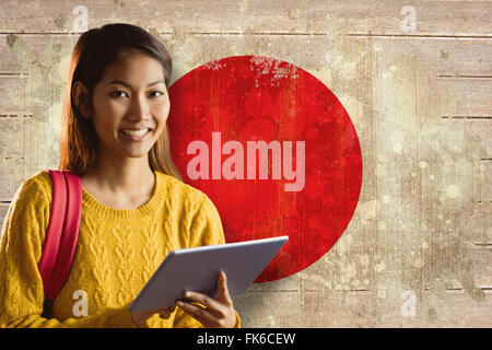 Zusammengesetztes Bild des lächelnden asiatische Studentin mit tablet Stockfoto