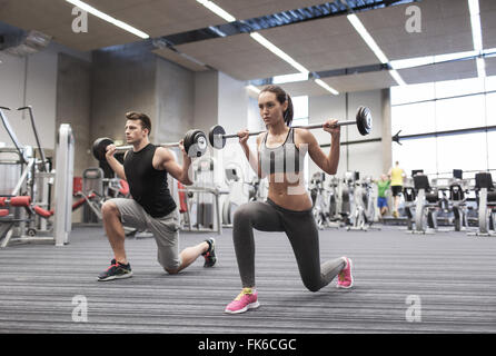 junger Mann und Frau mit Langhantel im Fitness-Studio trainieren Stockfoto
