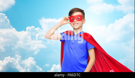 Junge im roten Superhelden Cape und Maske Stockfoto