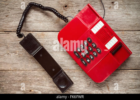 Vintage rote Telefon auf urigen Holzbrettern. Ansicht von oben. Stockfoto