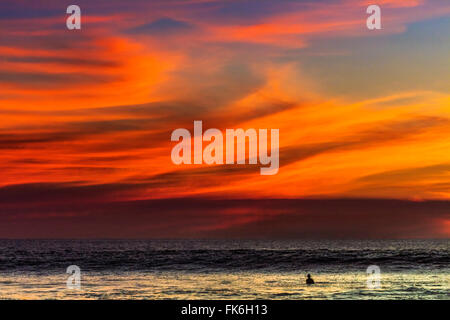 Einsamer Surfer und Sonnenuntergang Wolken vor Playa Hermosa Surf Beach, Nicoya Halbinsel, Santa Teresa, Puntarenas, Costa Rica Stockfoto