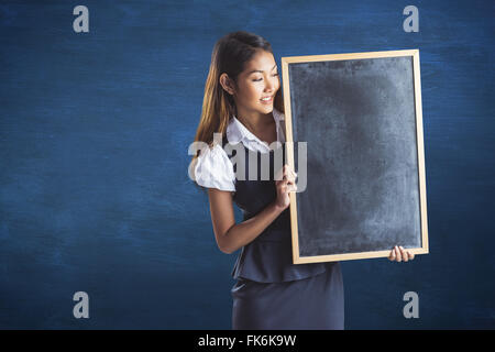 Zusammengesetztes Bild des lächelnden Geschäftsfrau hält eine Tafel Stockfoto