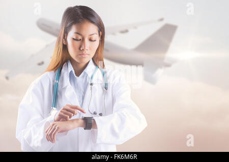 Zusammengesetztes Bild des asiatischen Arzt mit ihrer Smartwatch Stockfoto