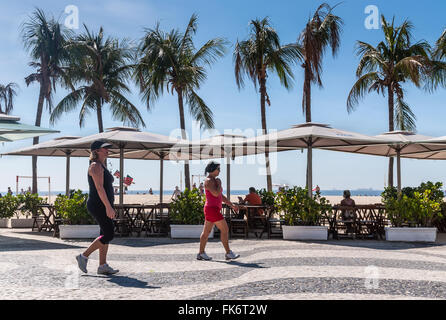 Frauen gehen am Strand der Copacabana in Rio De Janeiro. Stockfoto