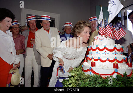 First Lady Nancy Reagan Geburtstagskerzen Ausblasen, während einer Party zu feiern Unabhängigkeitstag als Präsident Ronald Reagan, betrachten Earle Jorgensen und William Wilson auf Woodlawn Plantage 4. Juli 1981 in Mount Vernon, Virginia. Stockfoto