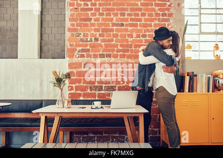 Porträt von Mann und Frau umarmt und grüßen einander in einem Coffee-Shop, paar, treffen in einem Café. Stockfoto