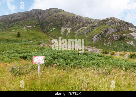 Ein No Camping Zeichen in Glen Coe Landscape in den westlichen Highlands von Schottland, richtet sich an diejenigen, die einen wilden Campingplatz suchen Stockfoto