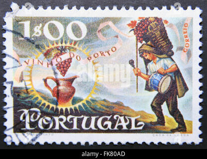 PORTUGAL - CIRCA 1970: eine Briefmarke gedruckt in Portugal Wein von Oporto, gewidmet zeigt Arbeiter tragen Korb von Trauben und Krug, Stockfoto