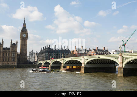 Schlepper ziehen ein Schiff mit Containern entlang der Themse in London. Westminster Brücke Stockfoto