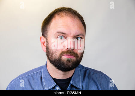 Der Mensch in seiner Mitte-30 Posen für ein Studioportrait mit einem halb weißen Hintergrund. Stockfoto