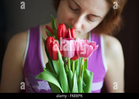 Haufen von Tulpen in den Händen der Frau. Das Ferienhaus von Lenz und Liebe. Internationaler Frauentag am 8. März. Soft-Fokus Stockfoto