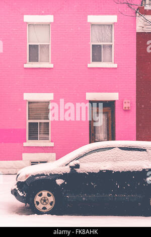 Montreal, ca, 7. März 2016. schwarzes Auto mit Schnee vor Rosa traditionelles Haus im Schnee Sturm abgedeckt Stockfoto