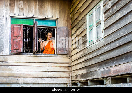 Asien. Süd-Ost-Asien. Laos. Provinz von Vang Vieng. Vang Vieng. Junger Mönch Blick durch ein Fenster. Stockfoto