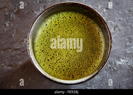 Grünen Matcha Tee mit Bubbles über Ansicht mit Schneebesen und Pulver und Löffel Stockfoto