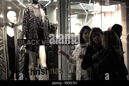 Ein Frauen-Blick in ein Schaufenster. Am Tag der schwarzen Freitag Shops sind überfüllt und die Türen sind spät geöffnet. Stockfoto