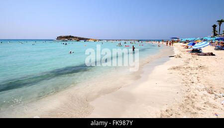 Touristen am Strand von Nissi Bucht in Agia Napa, Zypern entspannen und genießen ihren Sommerurlaub. Stockfoto