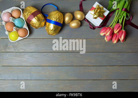 Ostereier und Frühjahr Tulpen über einen hölzernen Tisch Stockfoto
