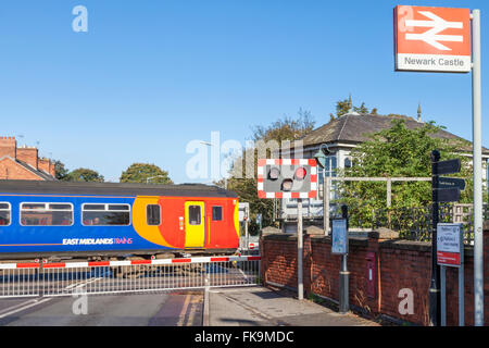 Reisen über einen Bahnübergang und Ankunft am Newark Castle Bahnhof, Newark-on-Trent, Nottinghamshire, England, UK Zug Stockfoto