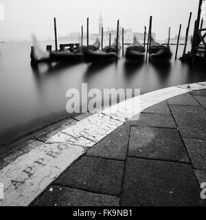 Venedig, Italien. Gondeln vor Anker in der Nähe von Markusplatz (Piazza San Marco) mit St. George Island und Kirche im Hintergrund. Stockfoto