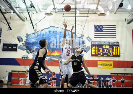 Ein High School Player freigeben, einen Schuß von der Oberseite des Schlüssels über ein Paar der gegnerischen Verteidiger. USA. Stockfoto