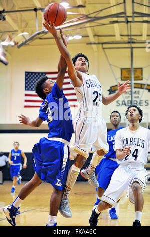 Nach einer Fahrt auf den Ring, mit dem ein Spieler sich an die Luft in einem Scoring Anstrengung über einen Verteidiger, während ein High School Basketball Spiel. USA. Stockfoto