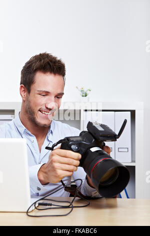 Professioneller Fotograf mit Kamera im Büro machen Image-backup Stockfoto