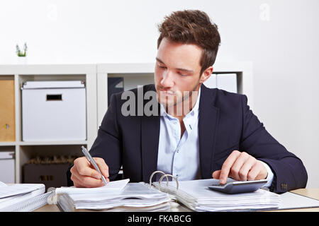 Geschäftsmann, arbeiten mit Rechner und Dateien im Büro Stockfoto