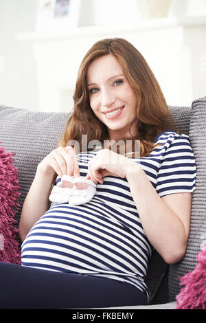 Porträt der schwangeren Frau mit Baby-Schuhe Stockfoto