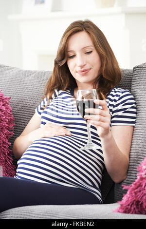 Pregnant Woman At Home Trinkglas Rotwein Stockfoto