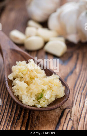 Zerdrückten Knoblauch (Nahaufnahme) auf rustikalen hölzernen Hintergrund Stockfoto