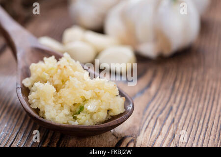 Zerdrückten Knoblauch (Nahaufnahme) auf rustikalen hölzernen Hintergrund Stockfoto