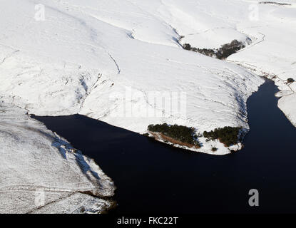 Luftaufnahme eines Reservoirs auf der Pennines, umgeben von Schnee bedeckt Hügel, UK Stockfoto