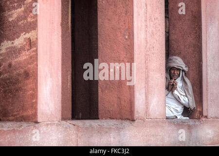 Mann sitzt zwischen den Säulen in Fatehpur Sikri; Agra; Uttar Pradesh; Indien; Stockfoto