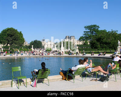 Menschen sitzen auf grüne Stühle rund um The Grand Bassin Rond, Jardin des Tuileries, Paris. Stockfoto