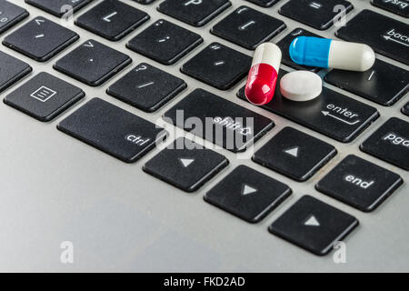 Pillen und Kapseln auf Notebook Tastatur, Arzt, Gesundheitswesen und Medizin Stockfoto