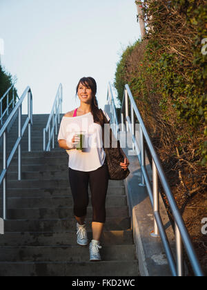 Junge Frau mit Treppen hinunter-smoothie Stockfoto