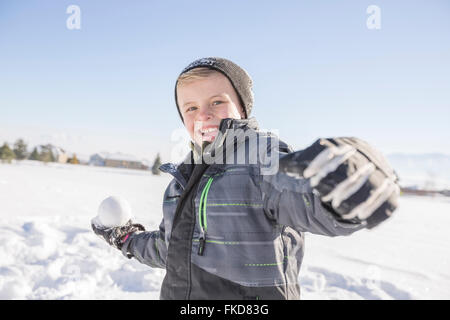 Jungen (8-9) werfen Schneeball Stockfoto