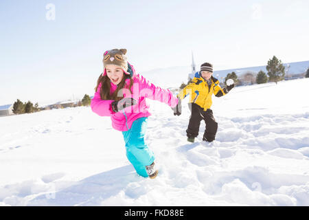 Kinder (8-9, 10-11) spielen im Schnee Stockfoto