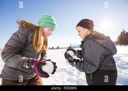 Kinder Schneebälle (8-9, 10-11) spielen mit Stockfoto