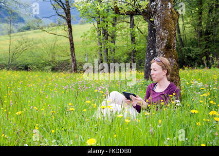 Frau mit dem e-Reader auf Wiese Stockfoto