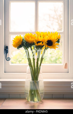 Sonnenblumen in Vase vor traditionellen Fenster Stockfoto