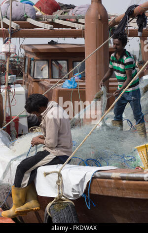 Zwei Fischer sind in der Regel Netze auf einem Boot in Kuwait Stockfoto